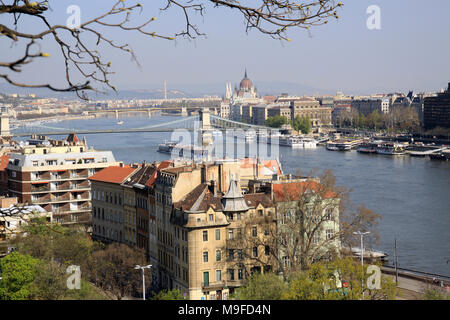 View over the rooftops and skyline of the Hungarian capital city of Budapest Hungary showing boats on the river Danube Stock Photo