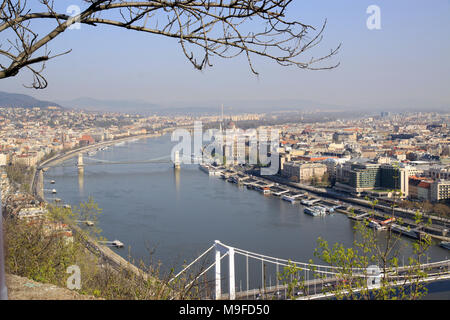 View over the rooftops and skyline of the Hungarian capital city of Budapest Hungary showing  boats  on the river Danube Stock Photo