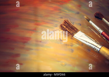 Creative background. Female artist hand holding colorful paintbrushes.  Paints and brushes background. Art class, art school. Pink artistic  background Stock Photo - Alamy