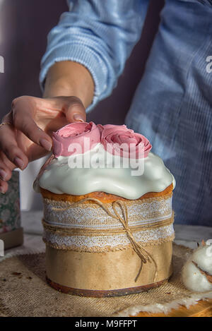 Easter cake in the hands of the girl cream to add to the cake Stock Photo