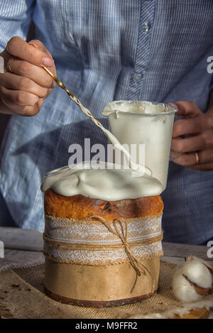 Easter cake in the hands of the girl cream to add to the cake Stock Photo