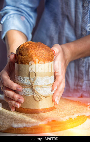 Easter cake in the hands of the girl cream to add to the cake Stock Photo