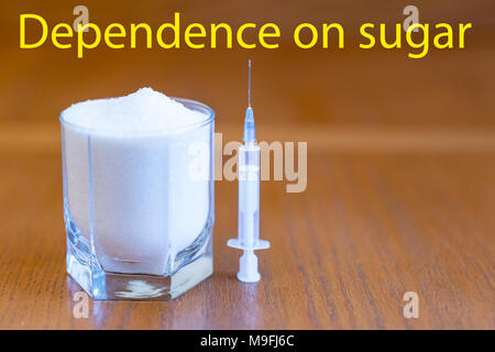 Sugar and syringe. the concept of dependence on the sweet. sugar is compared with drugs. inscription Dependence on sugar. Stock Photo