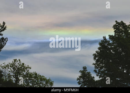 A rainbow over a cloudy sky and foggy landscape Stock Photo