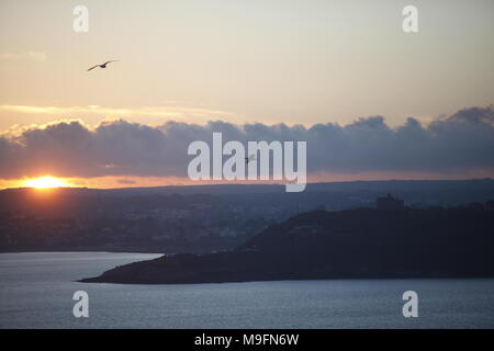 Pendennis Castle an artillery fort constructed by Henry VIII in Falmouth, is silhouetted against the setting sun, on Sunday March 25, 2018. Stock Photo