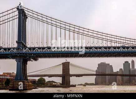 A view of the Manhattan and the Brooklyn bridge on a cloudy day, in New York. Photo taken from the ferry, while cruising East river. Stock Photo