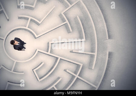 Confused business man trapped in a circular maze Stock Photo