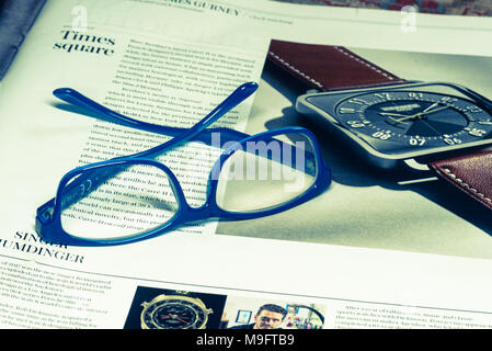 Reading glasses placed on financial newspaper Stock Photo