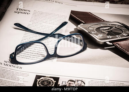 Reading glasses placed on financial newspaper Stock Photo