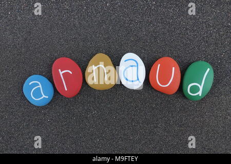 Arnaud, french masculine name with colored stones over black volcanic sand Stock Photo