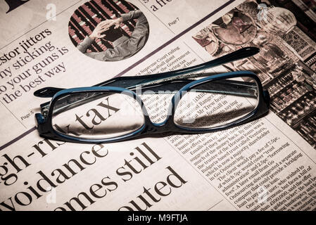 Reading glasses placed on financial newspaper Stock Photo