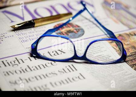 Reading glasses placed on financial newspaper Stock Photo