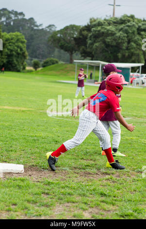 A junior softball player on third base ready to stretched and ready to run home. Stock Photo