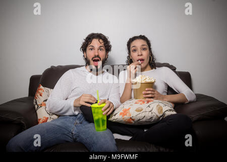 https://l450v.alamy.com/450v/m9fwmf/couple-is-scared-of-the-horror-movie-man-and-woman-are-at-home-eating-popcorn-and-watching-series-shes-eating-popcorn-he-is-holding-a-glass-of-dri-m9fwmf.jpg