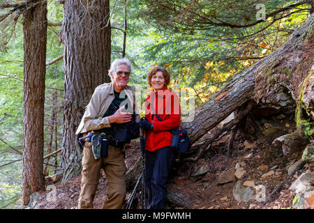 42,636.05955 Elderly married couple resting on a hike up Glacier Gulch Trail in an old growth conifer forest, near Smithers, British Columbia, Canada Stock Photo