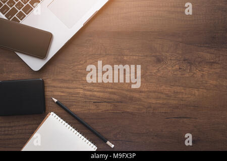 Top view of office wooden desk with Laptop,smartphone and supplies. copyspace Stock Photo