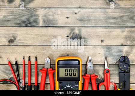 Close up of work tools for residential electrical installation on an aged wooden table. Space for text / announcement. Stock Photo