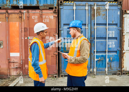 Dock Workers Discussing Shipping Stock Photo