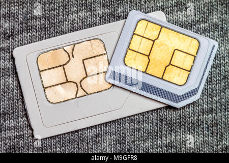 Set of mini and micro simcard. Isolated on grey cloth texture background Stock Photo