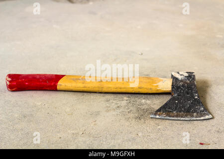 Old iron axe with wooden red and yellow handle isolated on white background. Handwork, labour and construction concept. Stock Photo