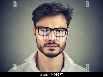 Close-up portrait of young handsome man with beard wearing white shirt and eyeglasses. Stock Photo