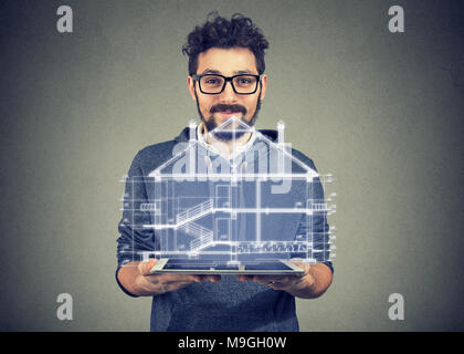 Bearded man in eye glasses using portable electronic pro tablet computer showing new home project Stock Photo
