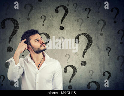Thoughtful confused handsome man has too many questions and no answer Stock Photo
