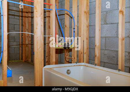 Bathroom remodel showing under floor plumbing work connecting old copper pipes to new plastic ones Remodeling a home bathroom, installation of pipes f Stock Photo
