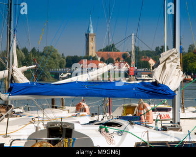 Yachts moored on Mikolajskie lake, townscape of Mikolajki in the background. Masurian Lakes District. Warmian-Masurian province, Poland. Europe. Stock Photo