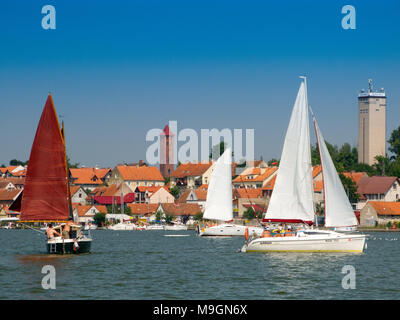 Yachts on Mikolajskie lake, townscape of Mikolajki in the background. Masurian Lakes District. Warmian-Masurian province, Poland. Europe. Stock Photo