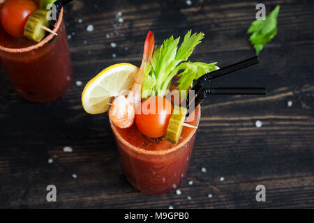 Bloody Mary Cocktail in glass with garnishes. Tomato Bloody Mary spicy drink on black background with copy space. Stock Photo
