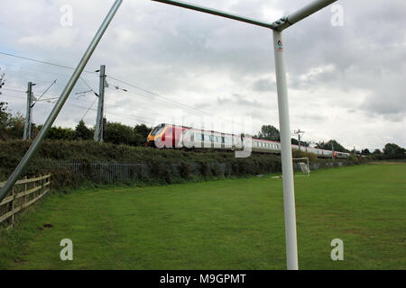A Virgin diesel train passes a set of portable football goals at Leisure centre at Penkridge as it approaches the Staffordshire village station. Stock Photo