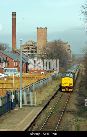 A railway enthusiast’s train passes Burscough Junction station and the former corn mill in West Lancashire. The train was called the Lancs Links tour. Stock Photo