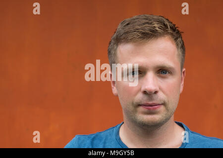 simple portrait of caucasian man on orange background. Stock Photo