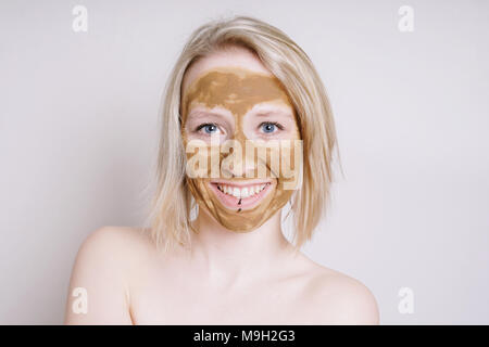 young woman with healing earth or clay beauty facial mask Stock Photo