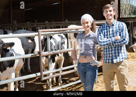 Two persons clapping cows in hangar and smiling Stock Photo - Alamy