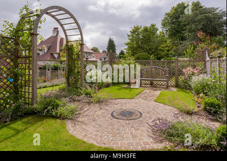 Summer plants, mosaic artwork, trellis screen, arbour archway & seat - beautiful, traditional, landscaped, designed garden - Yorkshire, England, UK. Stock Photo