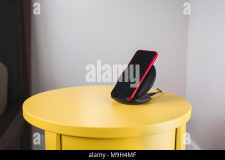 Smartphone on a wireless fast charger station Stock Photo