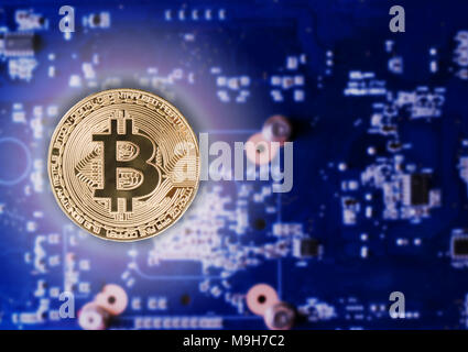 Physical Gold Bitcoin Coin on a computer video card. New independent worldwide cryptocurrency. Stock Photo