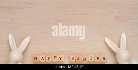 Happy Easter background with two rabbits on a bright wooden taxture Stock Photo