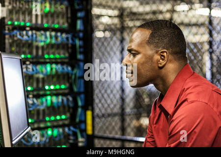 Black man technician doing diagnostic tests  on computer servers in server farm. Stock Photo