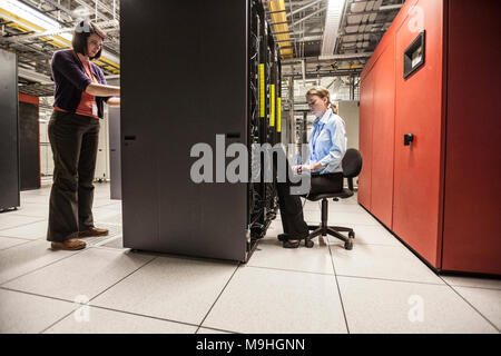 Caucasian women technicians working on computer servers in a server farm. Stock Photo