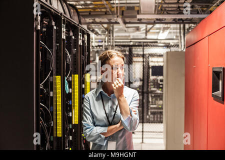 Caucasian woman technician working on computer servers in a server farm. Stock Photo