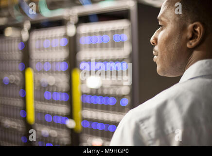 Black man technician doing diagnostic tests  on computer servers in server farm. Stock Photo
