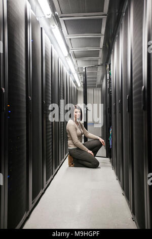 Caucasian woman technician working on computer servers in a server farm. Stock Photo