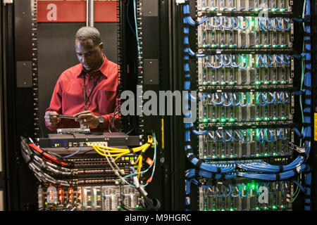Black man technician working on computer servers in server farm. Stock Photo