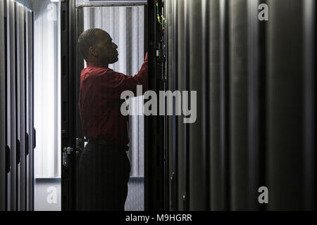 Black man technician working on computer servers in server farm. Stock Photo