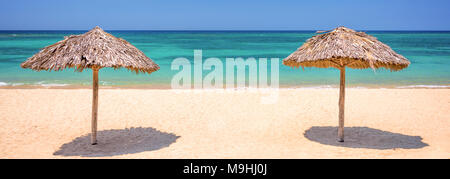 Two straw umbrellas on a beautiful tropical beach, panoramic travel background, travel and tourism concept Stock Photo