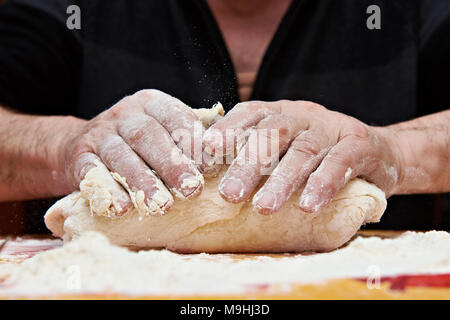 Mens hands knead the dough Stock Photo