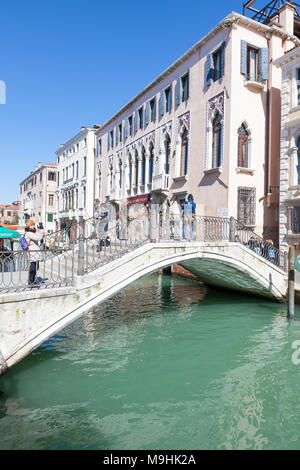 Ponte dei Greci, Rio dei Greci, Castello, Venice, Veneto, Italy with tourists admiring te view on a sunny blue sky day Stock Photo